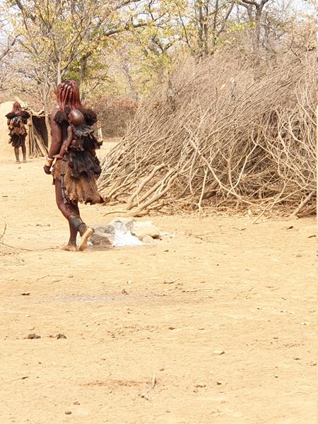 Opuwo recinto Himba ed una donna che cammina